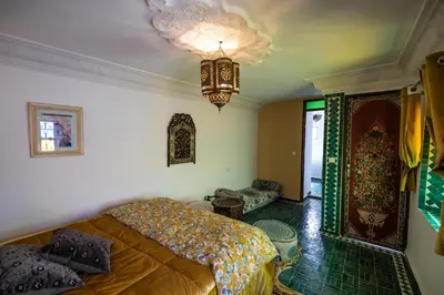 a bedroom with a bed and a chandelier at Riad Le Moucharabieh in Fès