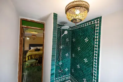 a bathroom with a shower and a chandelier at Riad Le Moucharabieh in Fès