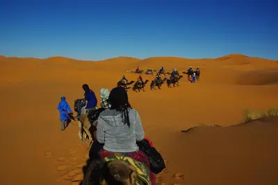 a group of people riding horses in the desert at Desert Camel Trekking Camp in Hassilabied