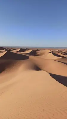 a group of sand dunes in the desert at Nomadic Stay in Mhamid