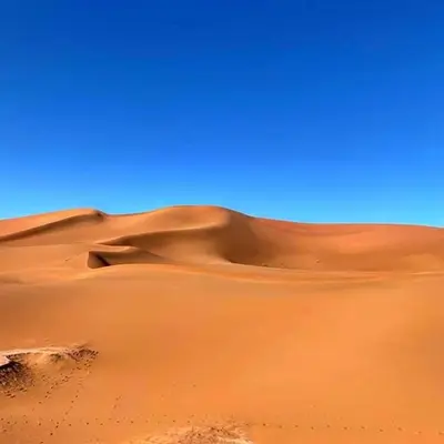 a sand dune in the middle of a desert at Nomadic Stay in Mhamid