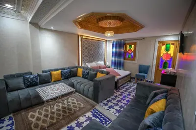 a living room with a couch and a bed at Hotel & Ryad DALILA in Fès