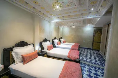 a bedroom with two beds and a coffered ceiling at Hotel & Ryad DALILA in Fès