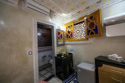 a bathroom with a shower and a toilet and a window at Hotel & Ryad DALILA in Fès