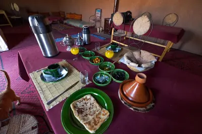 a table with a purple table cloth with food on it at Bivouac Le charme d'Aladdin in El Gouera