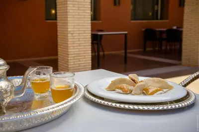 a table with a plate of food and two glasses of beer at Côté Sud in Ouarzazate