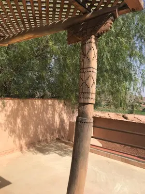 a wooden pergola with a view of a tree at Côté Sud in Ouarzazate