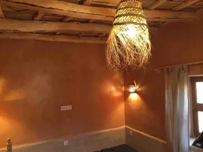 a dining room with a chandelier hanging from a ceiling at Berberbayt lodge maison privé in Tinerhir