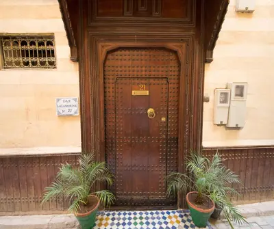 a wooden door with two potted plants in front of it at Dar Lalamoune in Fès