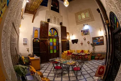 a room with a table and chairs in a building at Dar Lalamoune in Fès
