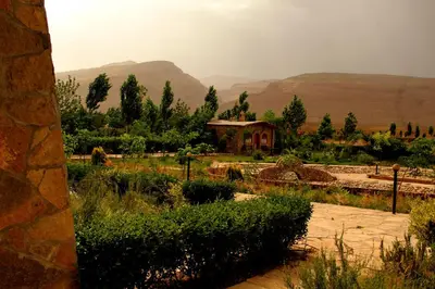 a view of a garden with mountains in the background at AZIGHAME Complexe Touristique in Tinerhir