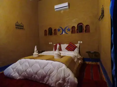 a bedroom with a large bed in a room at kasbah planet sahara in Merzouga