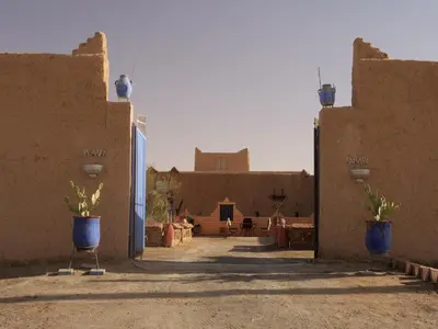 a courtyard of a building with two blue vases at kasbah planet sahara in Merzouga