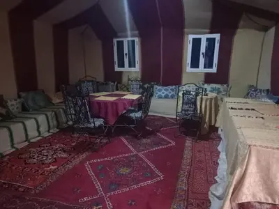 a room with a table and chairs and a couch at Erg Chegaga Camp & Activites in Mhamid