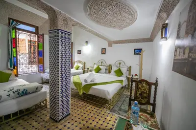 a bedroom with two beds in a room with a window at Riad Dar Rabha in Fès