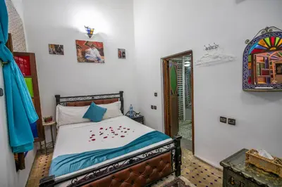a bedroom with a bed in a room with a mirror at Riad Dar Rabha in Fès