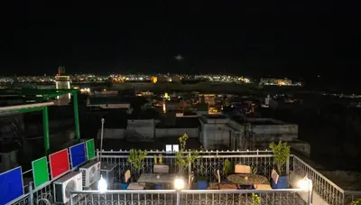 a balcony with a view of a city at night at Riad Dar Rabha in Fès