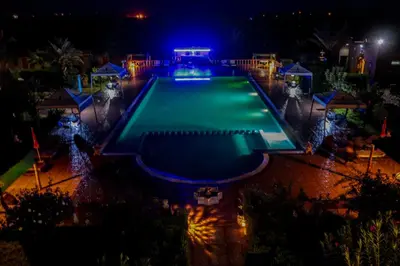 an overhead view of a swimming pool at night at Salma Palms Hôtel in Madkhal Meski