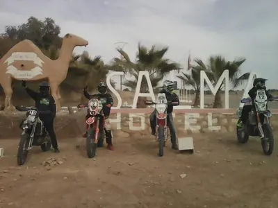 a group of people on motorcycles in front of a sign at Salma Palms Hôtel in Madkhal Meski