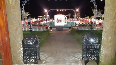 a view of a pool at night at Salma Palms Hôtel in Madkhal Meski