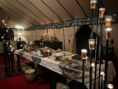 a dining room with a table in a tent at Luxury traditional Tent Camp in Merzouga