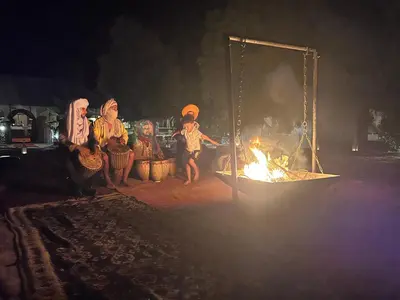 a group of people sitting around a fire at Luxury traditional Tent Camp in Merzouga