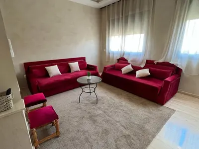 a living room with two red couches and a table at Suites Appartement Midelt in Midelt