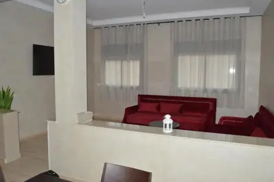 a living room with red chairs and a red couch at Suites Appartement Midelt in Midelt