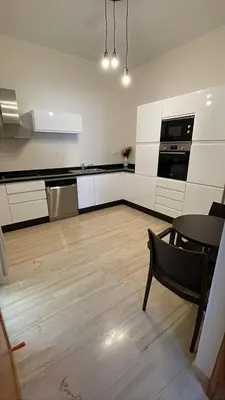 a kitchen with white cabinets and a table and a chair at Suites Appartement Midelt in Midelt