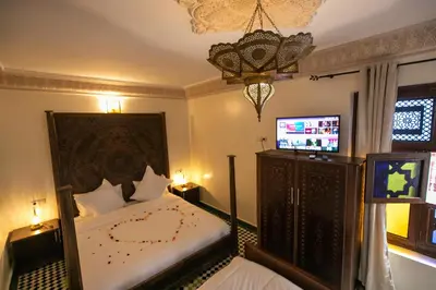 a bedroom with a bed and a tv in a room at Riad Anis Fes in Fès