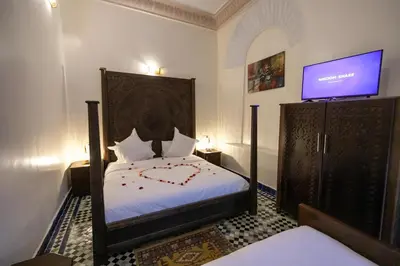 a bedroom with a bed with a tv on the wall at Riad Anis Fes in Fès