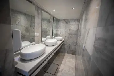 a bathroom with three toilets on a counter with mirrors at Riad Anis Fes in Fès