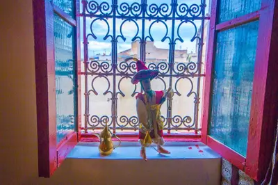 a child standing in a window with an umbrella at Riad Hayat Fes in Fès
