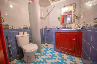 a bathroom with a toilet and a red cabinet at Riad Hayat Fes in Fès