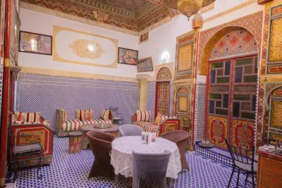 a restaurant with a table and chairs in a room at Riad Hayat Fes in Fès