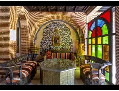 a room with two benches and a table and a window at Palace with 2 villas and 2 swimming pools in Sidi Abdellah Ghiat in Had Abdallah Rhiat