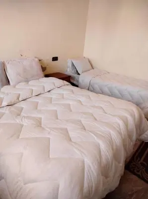 a room with two large beds in a room at Riad gnaoua khamlia in Merzouga
