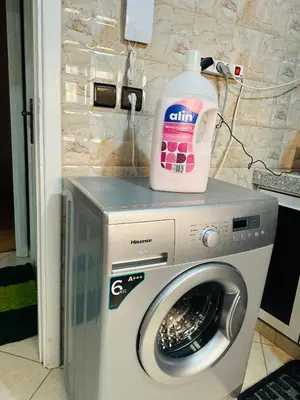 a bottle of laundry detergent sitting on top of a washing machine at The Best Stop in Midelt