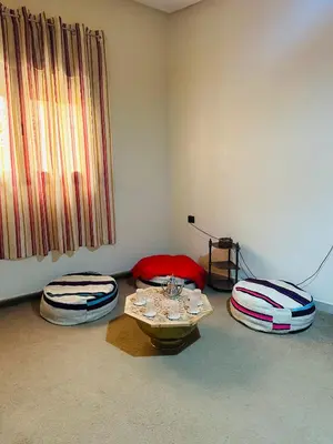 a room with two ottomans and a table in a room at The Best Stop in Midelt