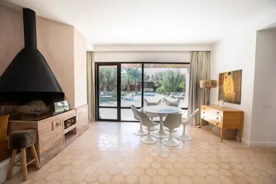 a living room with a table and a fireplace at Villa Mayaz - Piscine chauffée in Marrakech