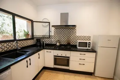 a kitchen with a white refrigerator and a microwave at Villa Mayaz - Piscine chauffée in Marrakech