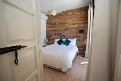 a bedroom with a white bed and a brick wall at Villa Mayaz - Piscine chauffée in Marrakech