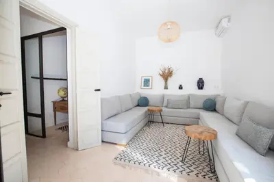 a white living room with a couch and a table at Villa Mayaz - Piscine chauffée in Marrakech