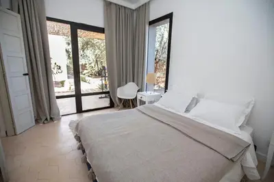 a bedroom with a large bed and a large window at Villa Mayaz - Piscine chauffée in Marrakech