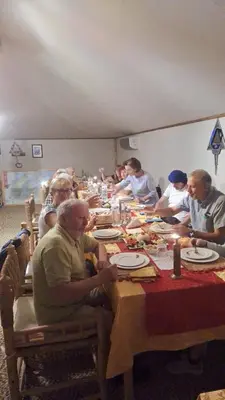 a group of people sitting at a long table at Abdo Luxury Camp with Heating in Merzouga