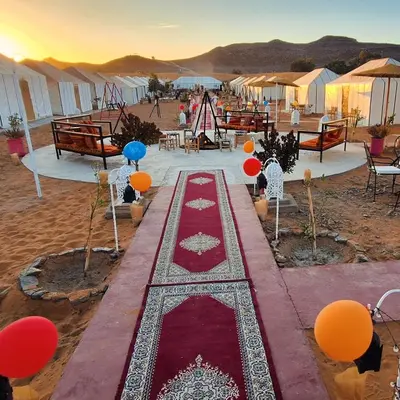 a group of tents in the desert with a red carpet at Abdo Luxury Camp with Heating in Merzouga