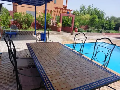 a table and chairs next to a swimming pool at Villa yanii siin in Marrakech