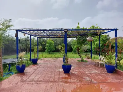 a pergola with potted plants on a brick patio at Villa yanii siin in Marrakech