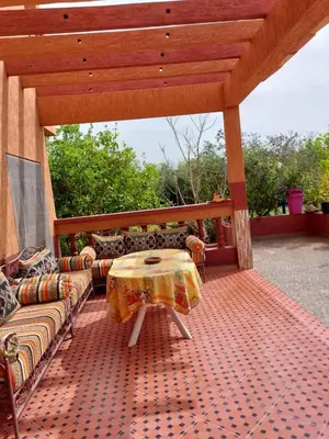 a patio with a table and couches on a deck at Villa yanii siin in Marrakech