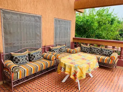 a patio with two couches and a table and two windows at Villa yanii siin in Marrakech